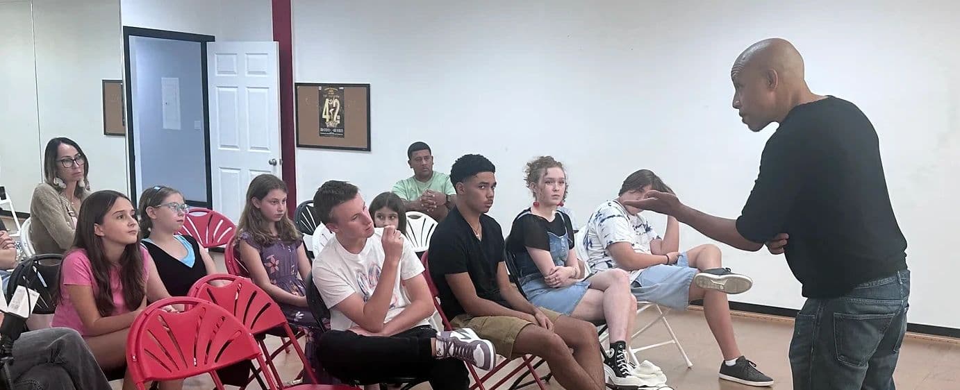 A Mouseketeer leading a coaching session with a group of young students